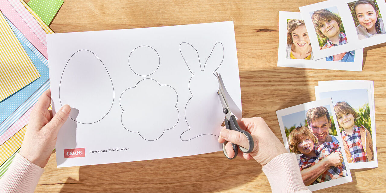 Dvije ruke režu uskršnje zečeve iz predloška. Desno od toga su izrađene fotografije obitelji, a lijevo razni listovi plastelina.