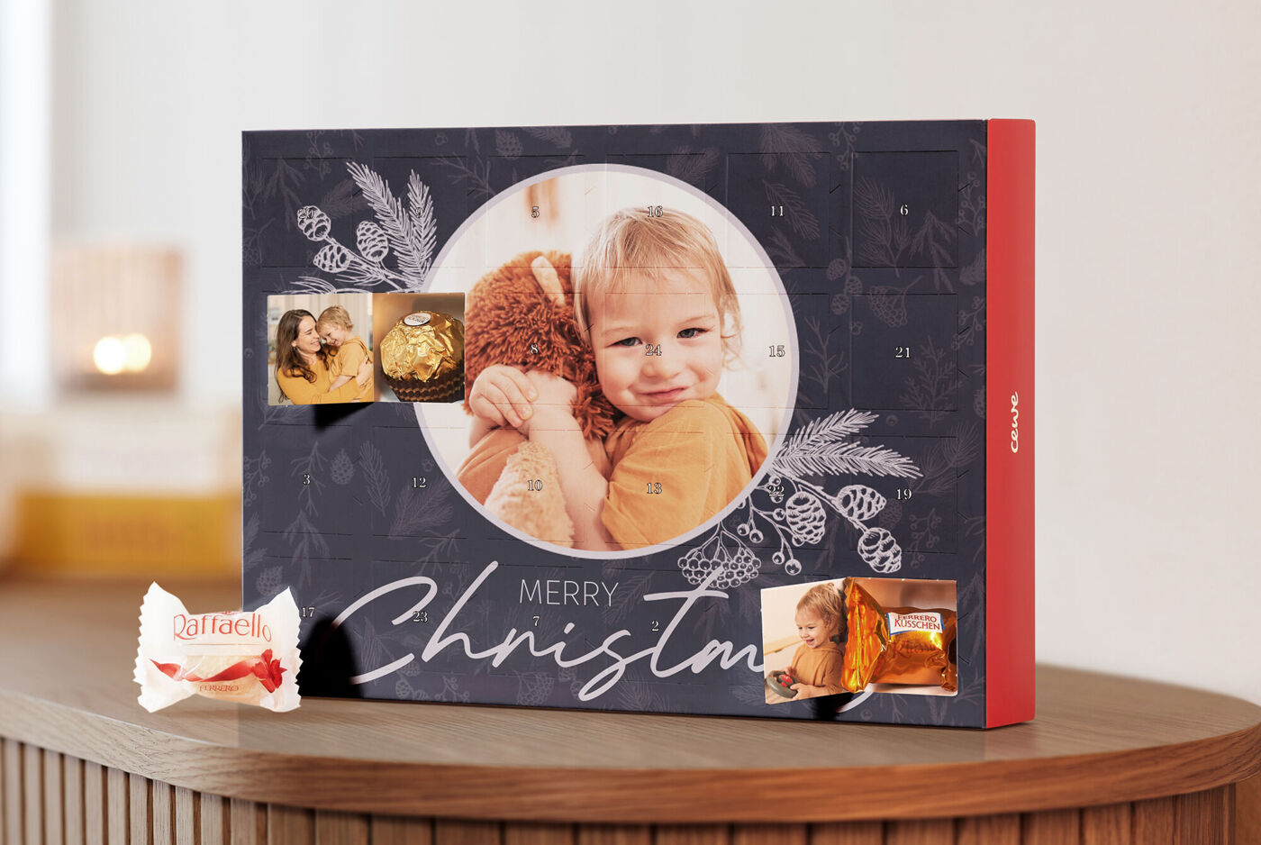 Svečani adventski kalendar s velikom fotografijom i malim slikama na naslovnici, prikazuje božićne motive i natpis 'MERRY CHRISTMAS'.